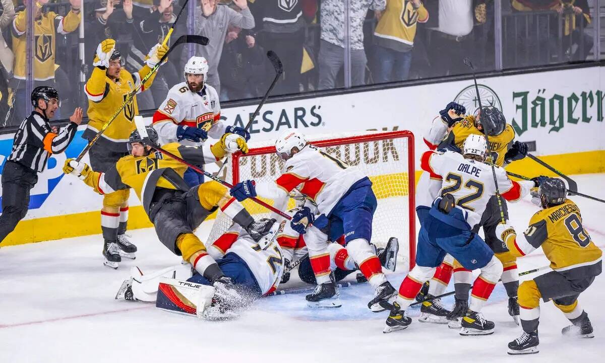 El defensa de los Golden Knights Nicolas Hague (14) es golpeado hacia atrás después de anotar ...