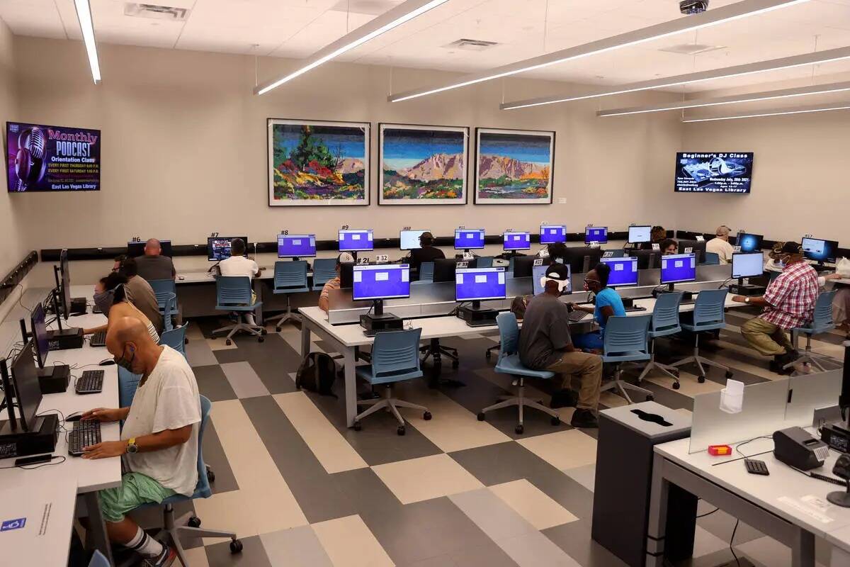 Un grupo de personas usa la sala de computadoras de la Biblioteca del Este de Las Vegas en agos ...