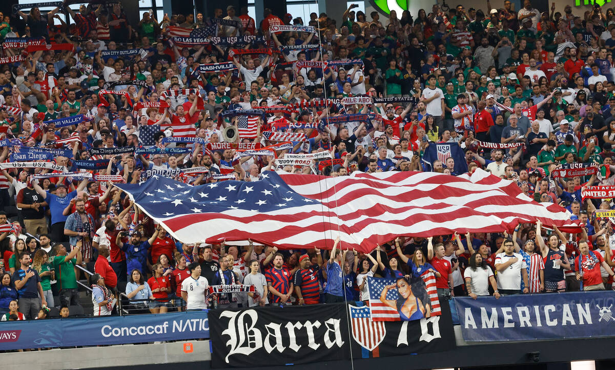 Aficionados estadounidenses sostienen banderas estadounidenses en partido de semifinal de la Li ...