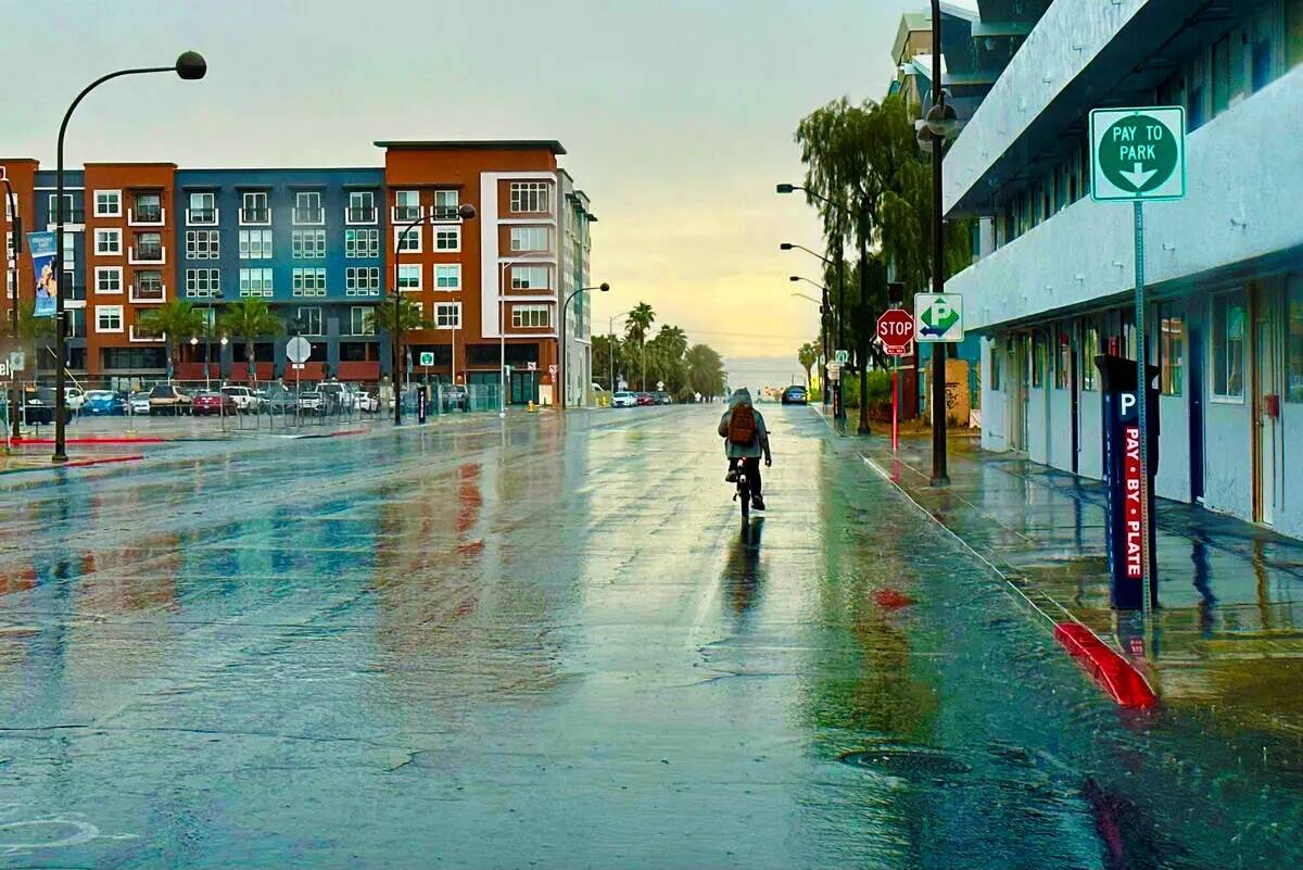 Un hombre anda en bicicleta bajo la lluvia en East Carson Avenue el viernes 16 de junio de 2023 ...