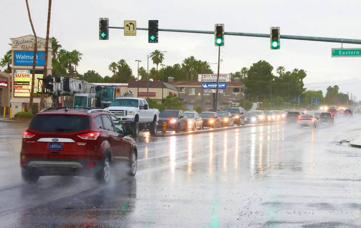 Un auto circula por la intersección de Warms Springs road y Eastern Avenue durante una torment ...