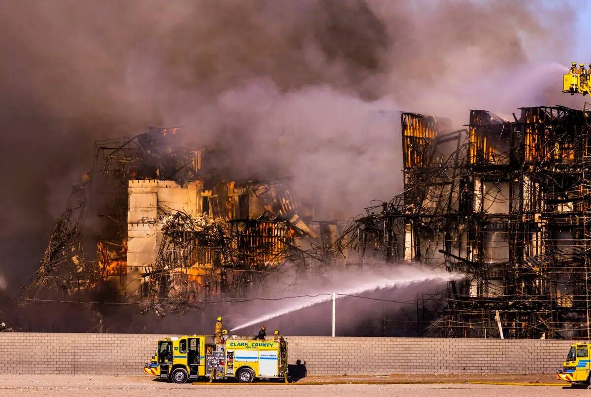 Los bomberos trabajan para extinguir un incendio en un complejo residencial en construcción ce ...