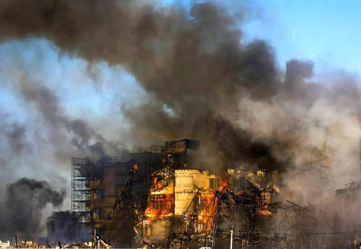 Los bomberos trabajan para extinguir un incendio en un complejo residencial en construcción ce ...