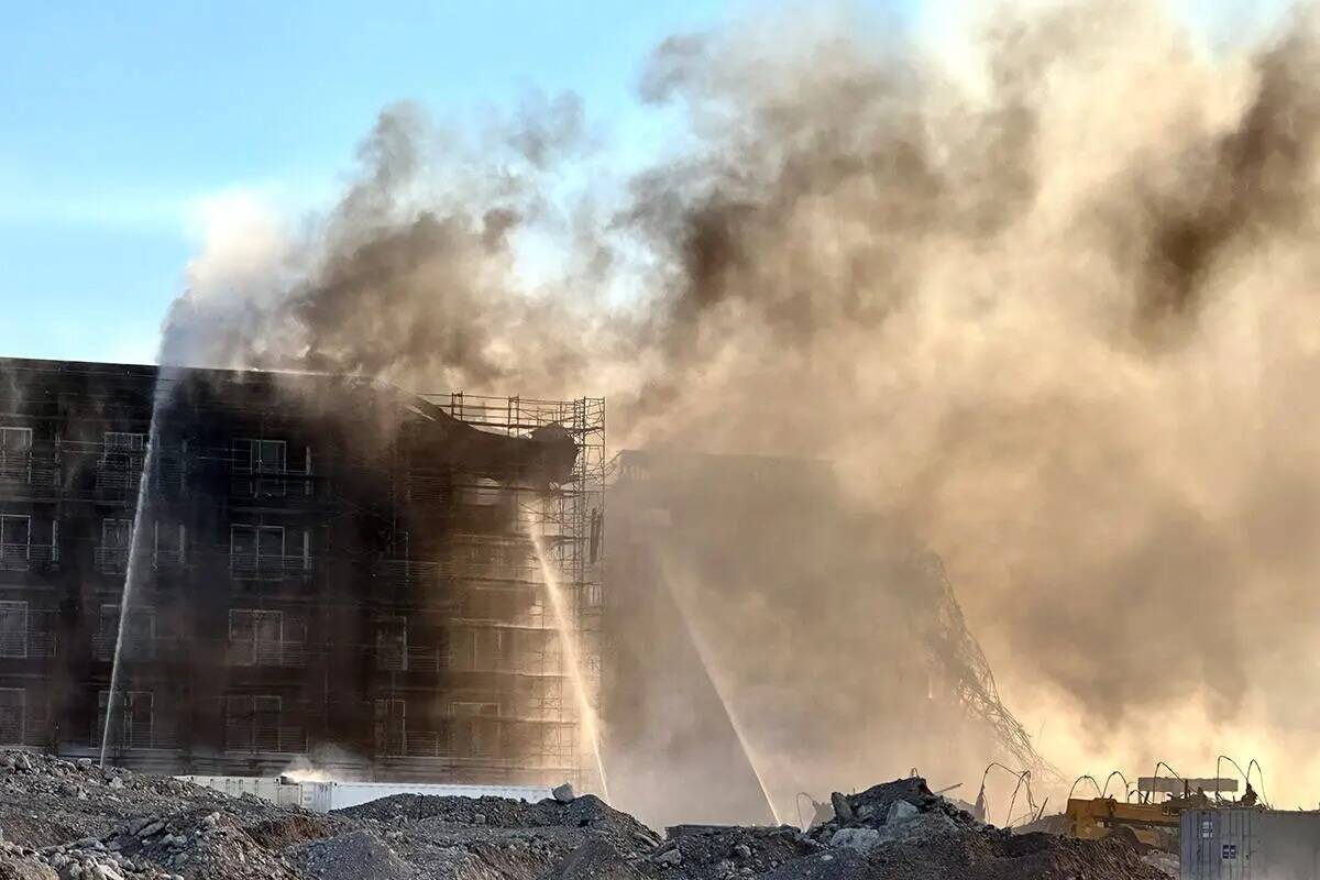 Los bomberos trabajan para extinguir un incendio en un complejo residencial en construcción ce ...