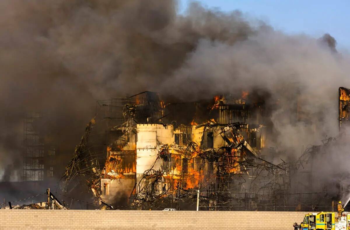 Los bomberos trabajan para extinguir un incendio en un complejo residencial en construcción ce ...