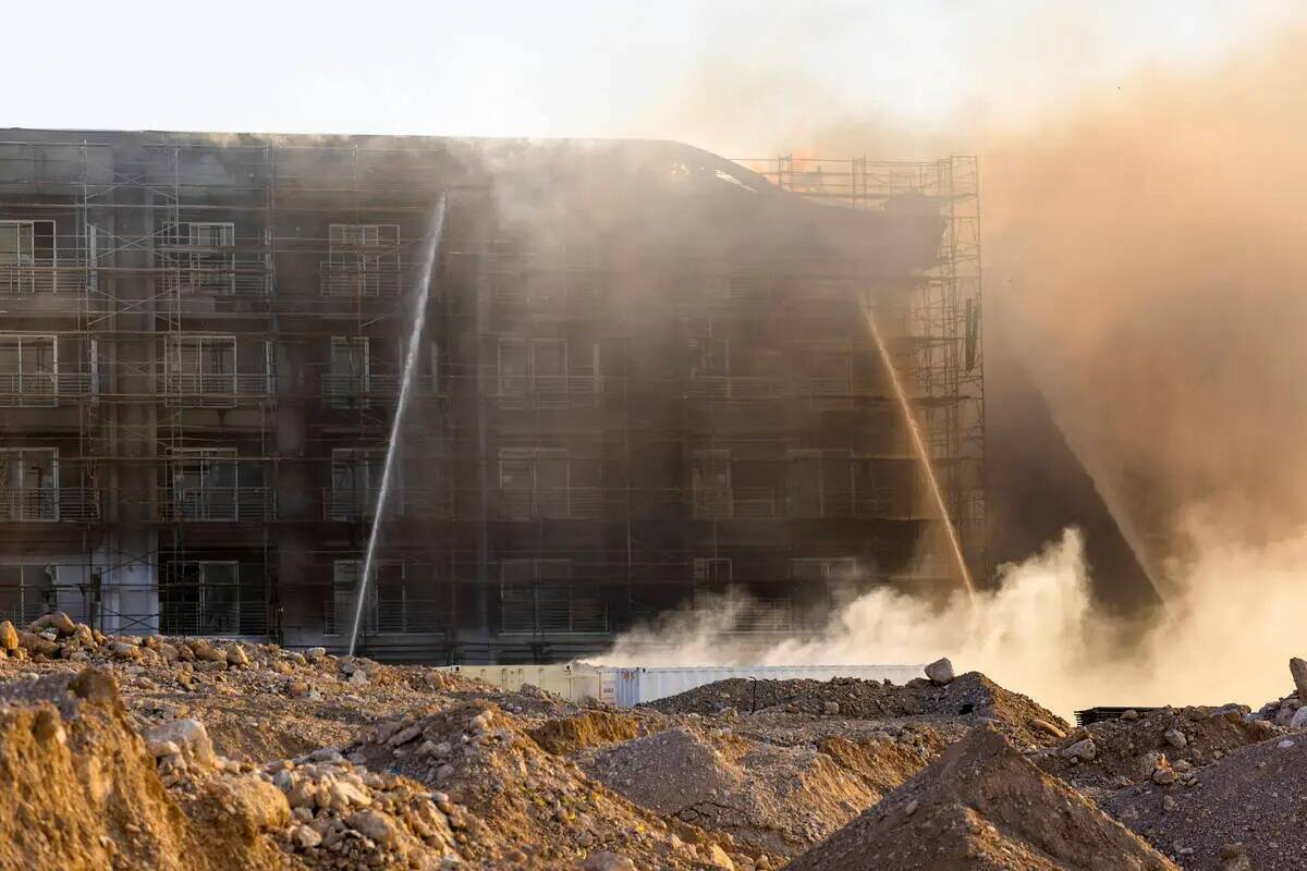 Los bomberos trabajan para extinguir un incendio en un complejo residencial en construcción ce ...