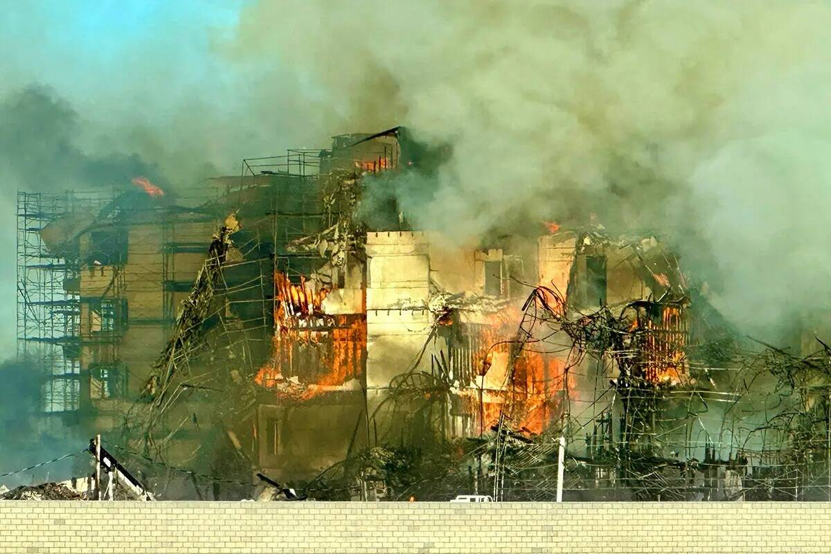 Los bomberos trabajan para extinguir un incendio en un complejo residencial en construcción ce ...