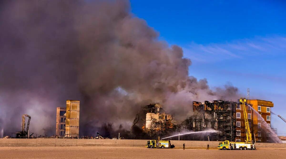 Los bomberos trabajan para extinguir un incendio en un complejo residencial en construcción ce ...