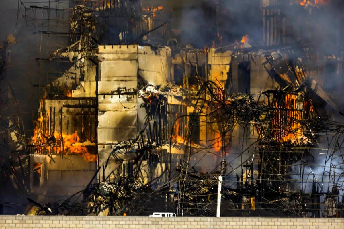 Los bomberos trabajan para extinguir un incendio en un complejo residencial en construcción ce ...