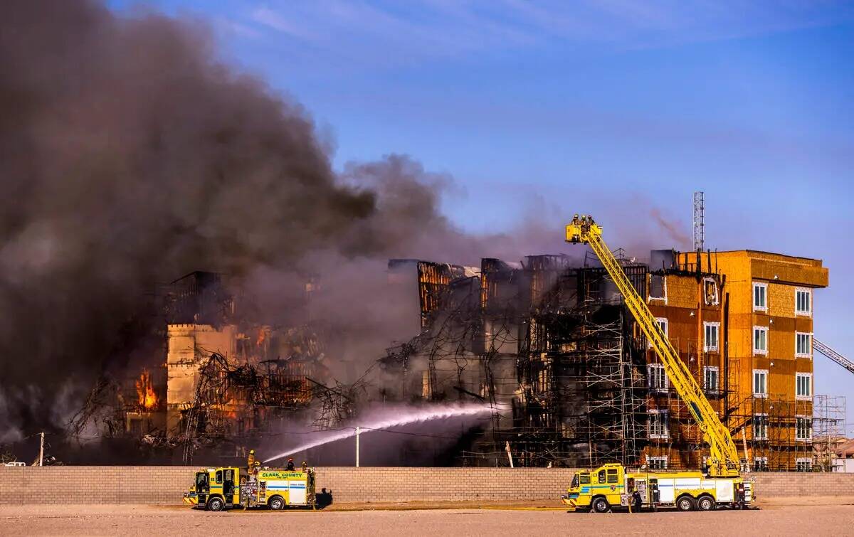 Los bomberos trabajan para extinguir un incendio en un complejo residencial en construcción ce ...