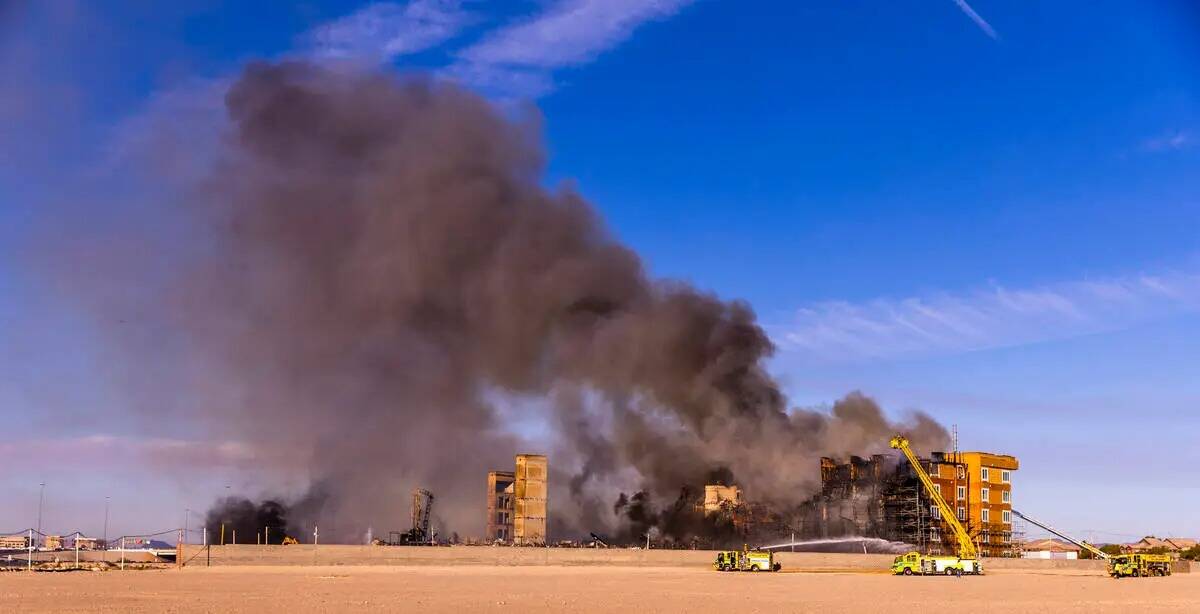 Los bomberos trabajan para extinguir un incendio en un complejo residencial en construcción ce ...