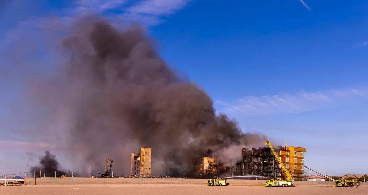 Los bomberos trabajan para extinguir un incendio en un complejo residencial en construcción ce ...