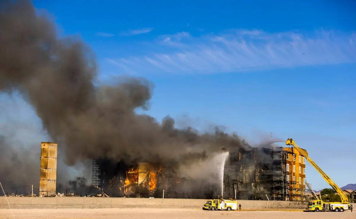 Los bomberos trabajan para extinguir un incendio en un complejo residencial en construcción ce ...