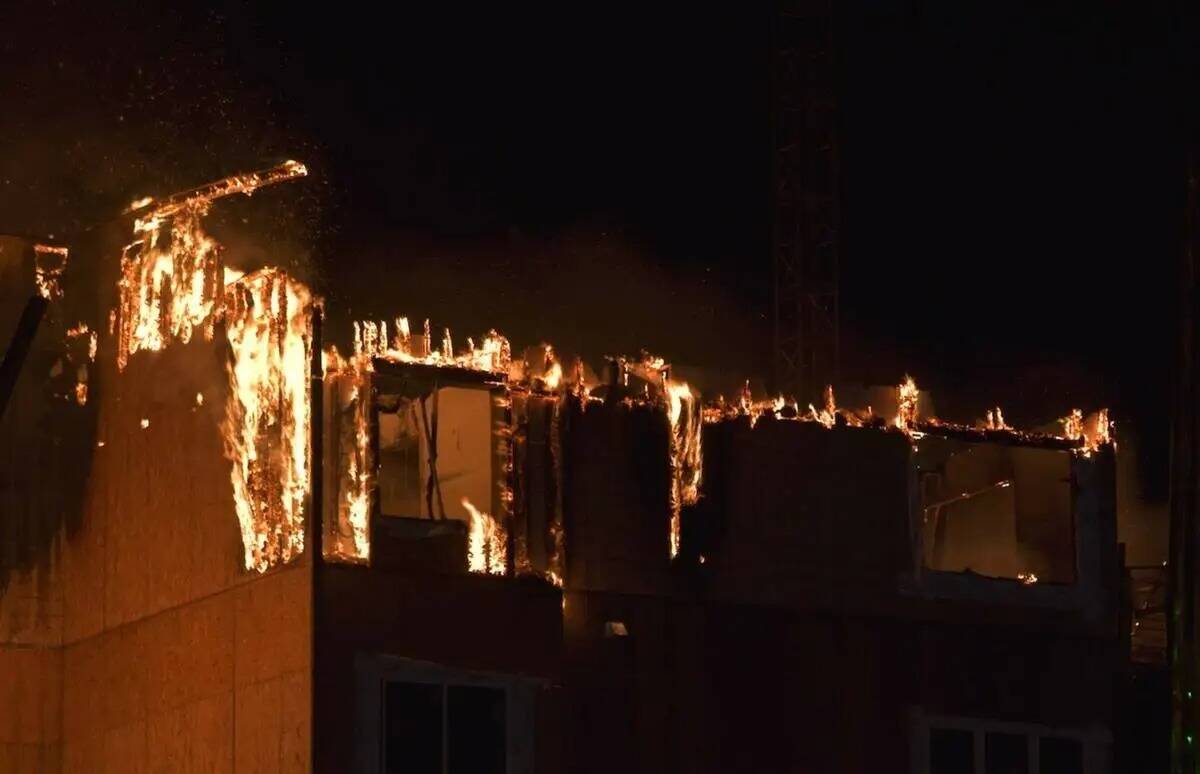 Los bomberos trabajan para extinguir un incendio en un complejo residencial en construcción ce ...