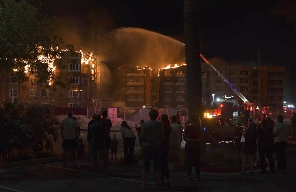 Los bomberos trabajan para extinguir un incendio en un complejo residencial en construcción ce ...