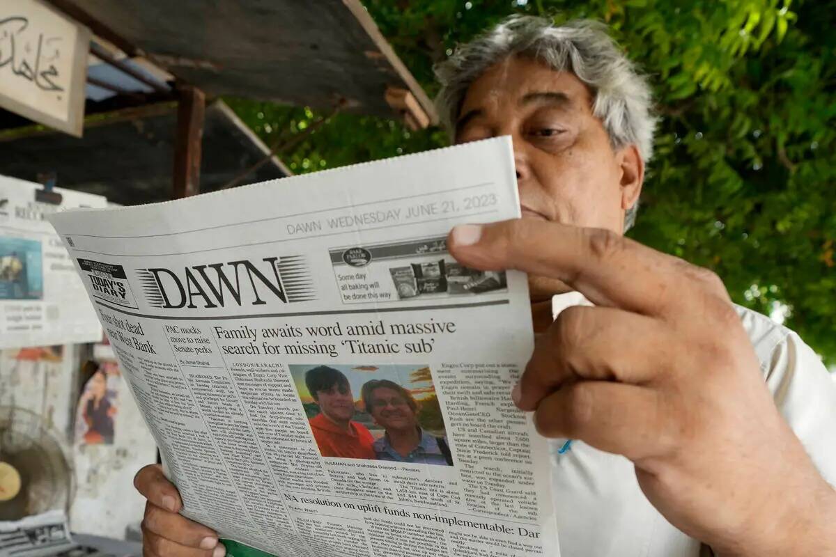 Un hombre lee un ejemplar de un periódico matutino que reporta la desaparición del sumergible ...
