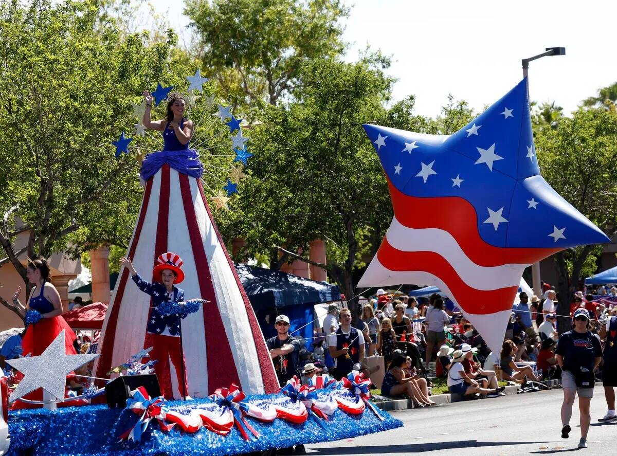 Una Miss Stars and Stripes de 15 pies saluda en el carro "America Standing Tall" durante el Des ...