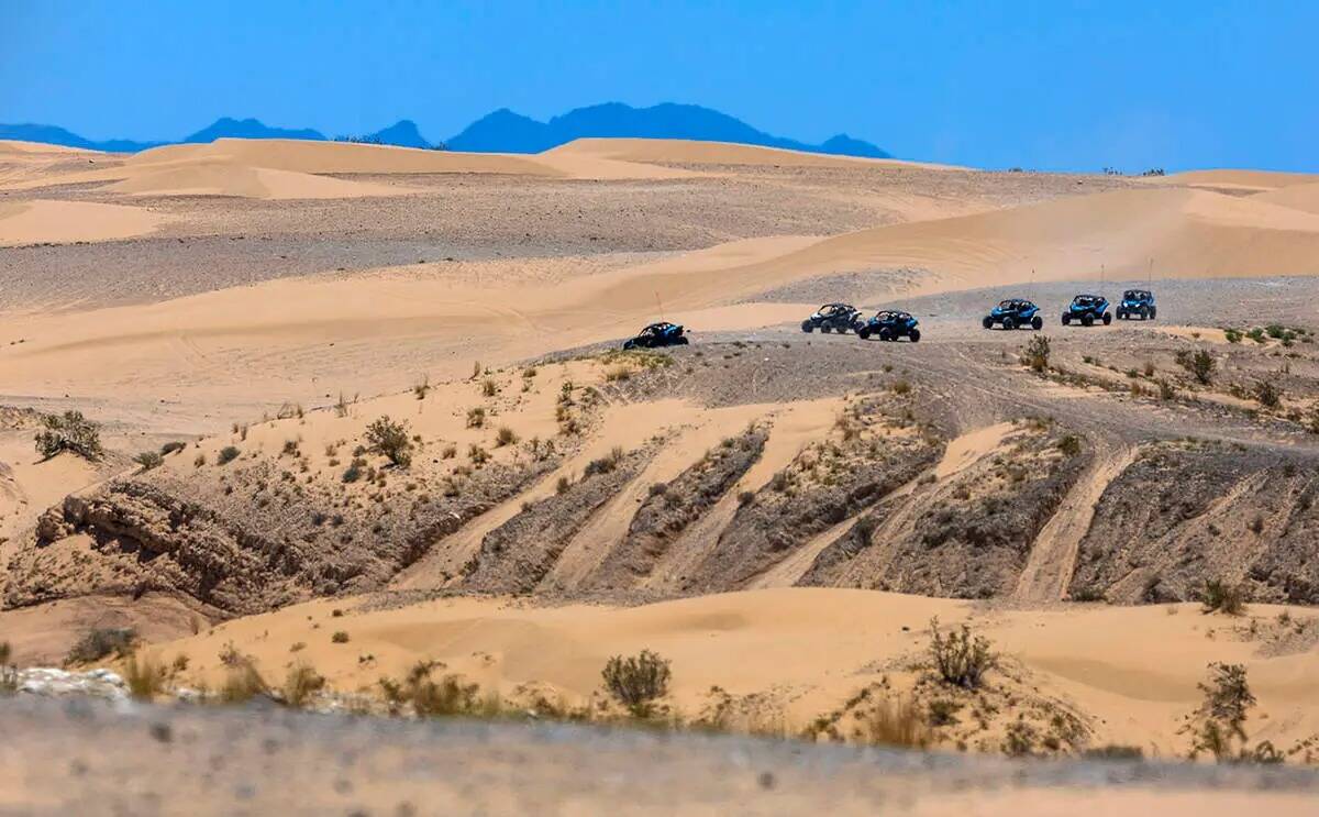 Unos buggies descienden desde lo alto de un aumento en las dunas de Nellis mientras el calor se ...