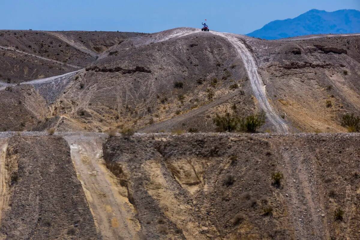 Un piloto de ATV llega a la cima de un aumento dentro de las dunas de Nellis mientras el clima ...