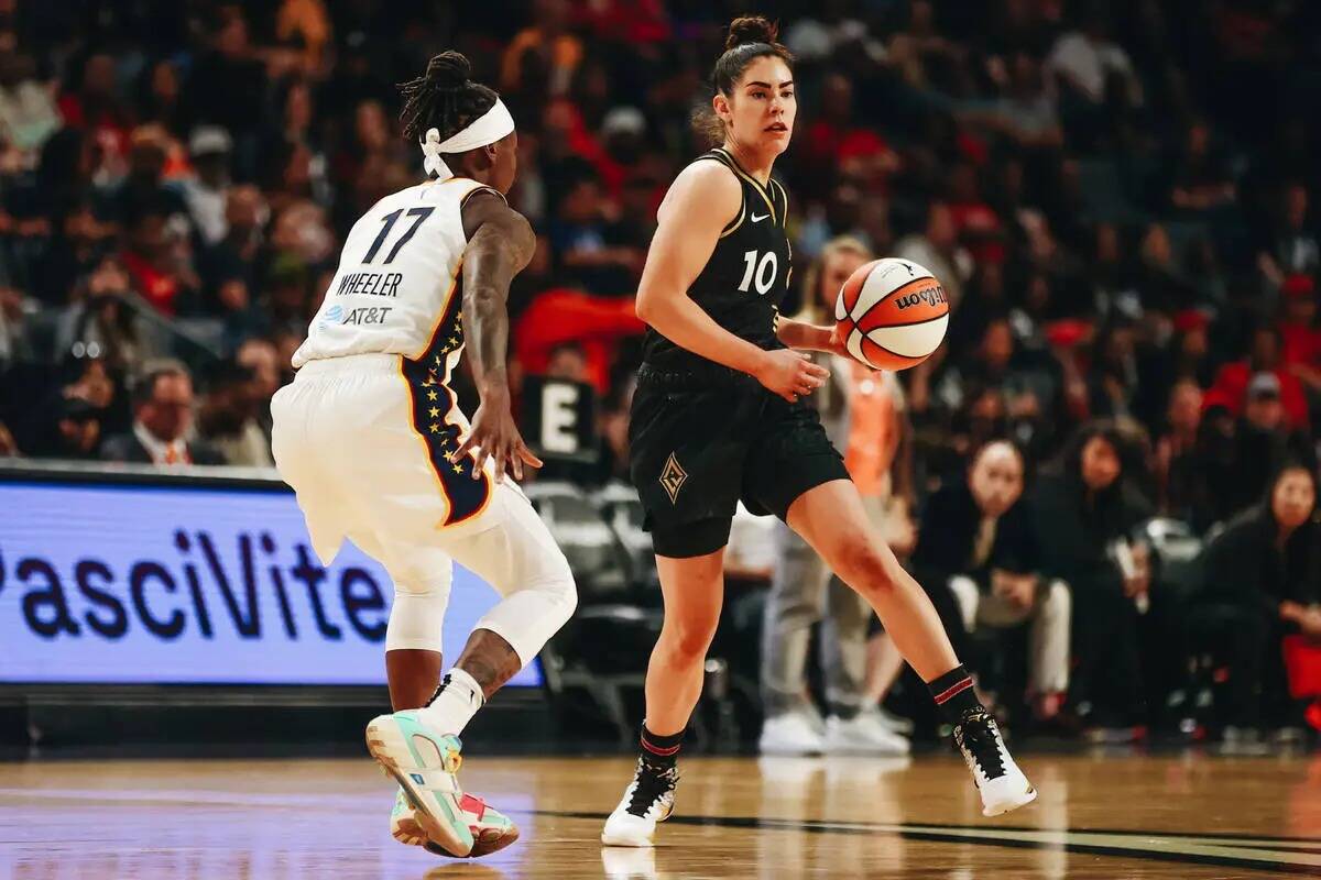 La escolta de Las Vegas Aces Kelsey Plum (10) busca pasar el balón a una compañera mientras l ...