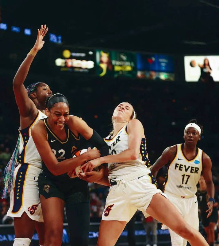 La pívot de Las Vegas Aces A'ja Wilson (22) lucha con la escolta de Indiana Fever Lexie Hull ( ...