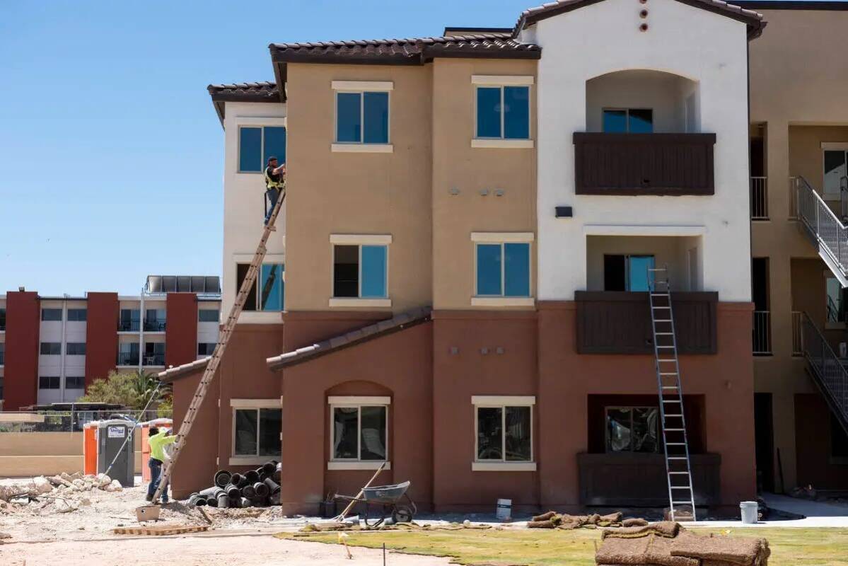 Los trabajadores dan los toques finales a un edificio en el complejo de viviendas asequibles De ...