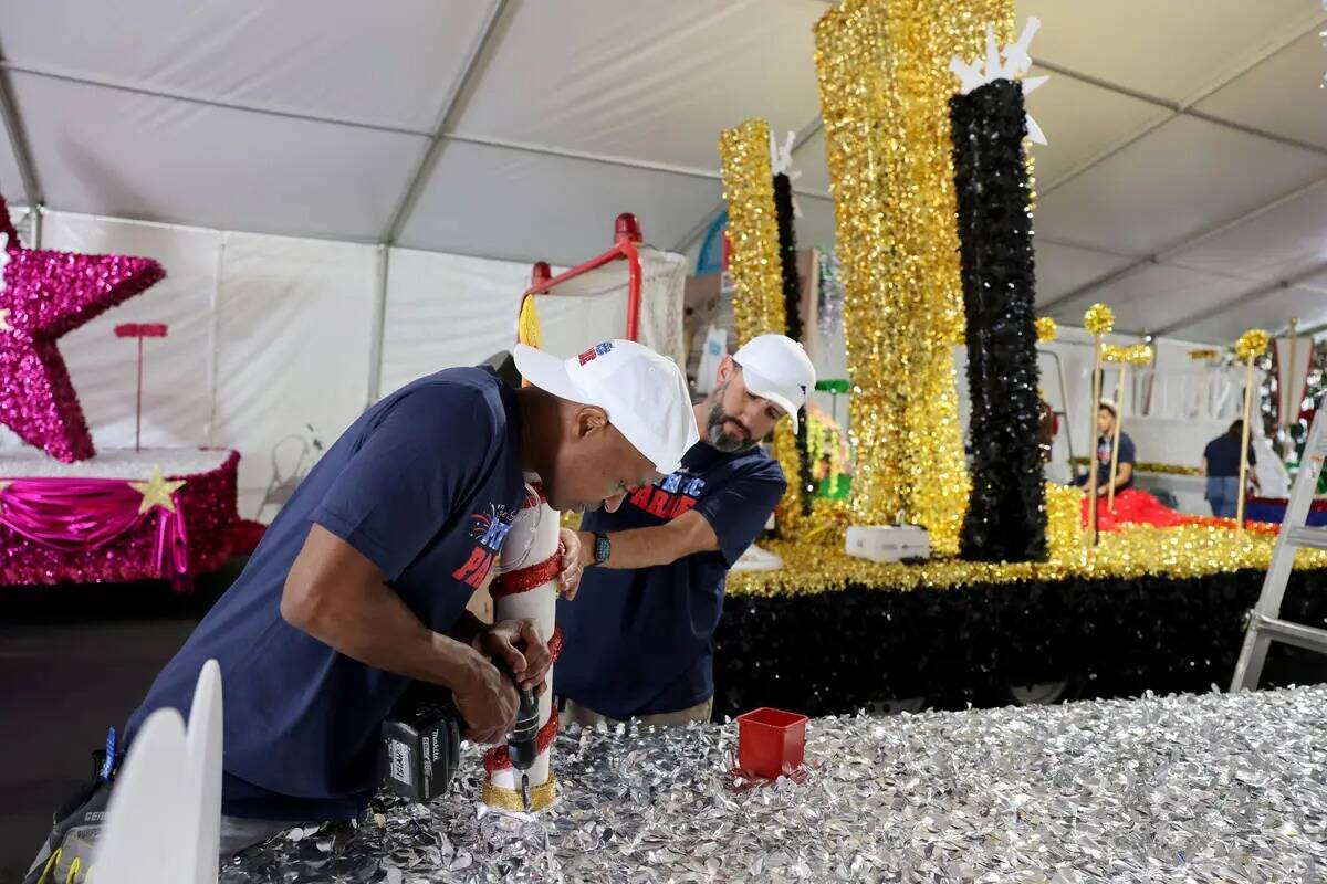 Los voluntarios Isiah Powell, a la izquierda, y Dave Bailey trabajan en un carro alegórico par ...