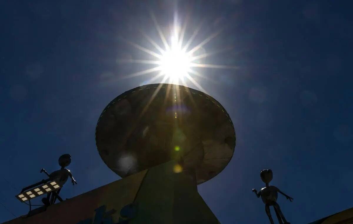Los rayos del sol atraviesan una escultura de alienígenas en el exterior de Artistic Iron Work ...