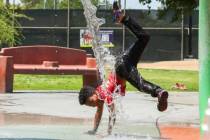 Trent Turner, de siete años, salta a través de los juegos de agua en Bob Baskin Park para ref ...