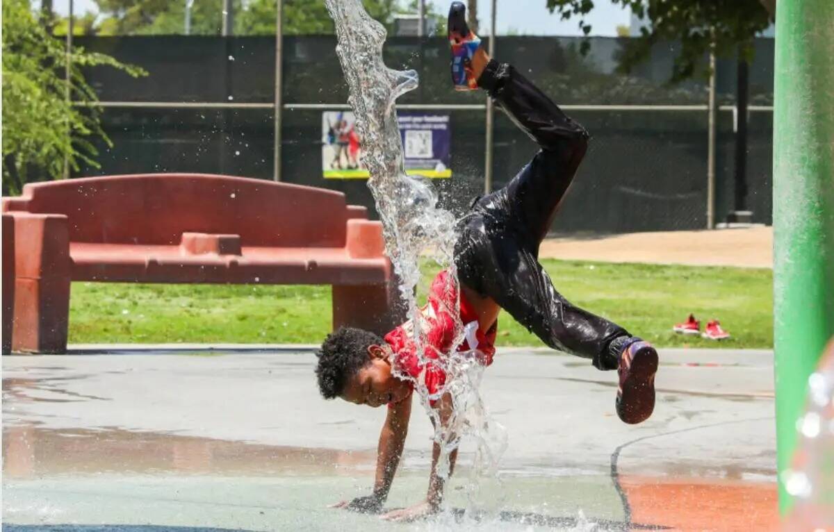 Trent Turner, de siete años, salta a través de los juegos de agua en Bob Baskin Park para ref ...