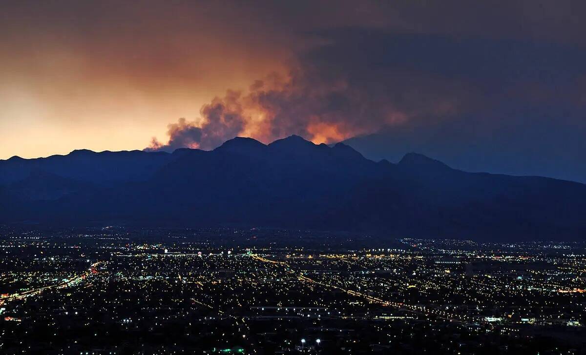 El humo se eleva desde el incendio forestal Carpenter 1 mientras el sol se pone sobre Las Vegas ...