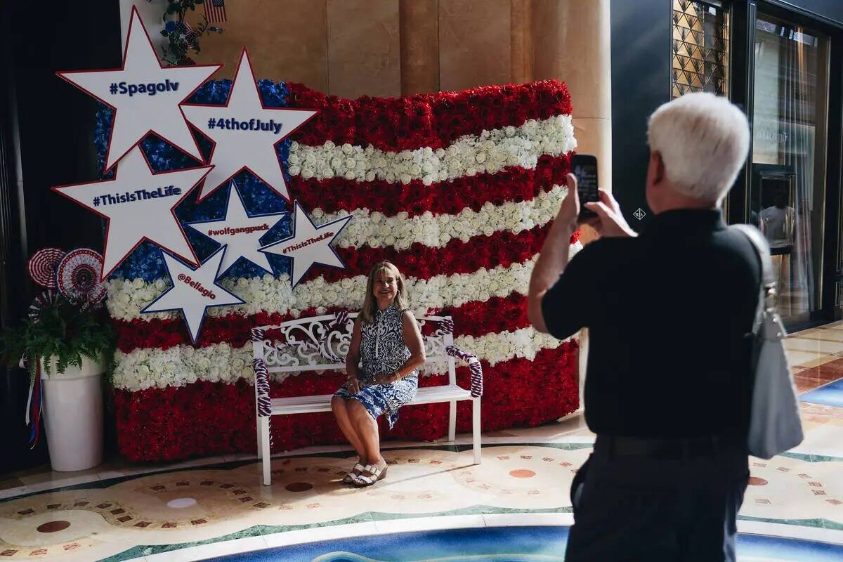 Turistas se toman fotos delante de una bandera estadounidense hecha de flores el martes 4 de ju ...