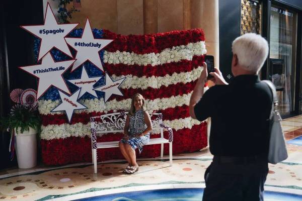 Turistas se toman fotos delante de una bandera estadounidense hecha de flores el martes 4 de ju ...