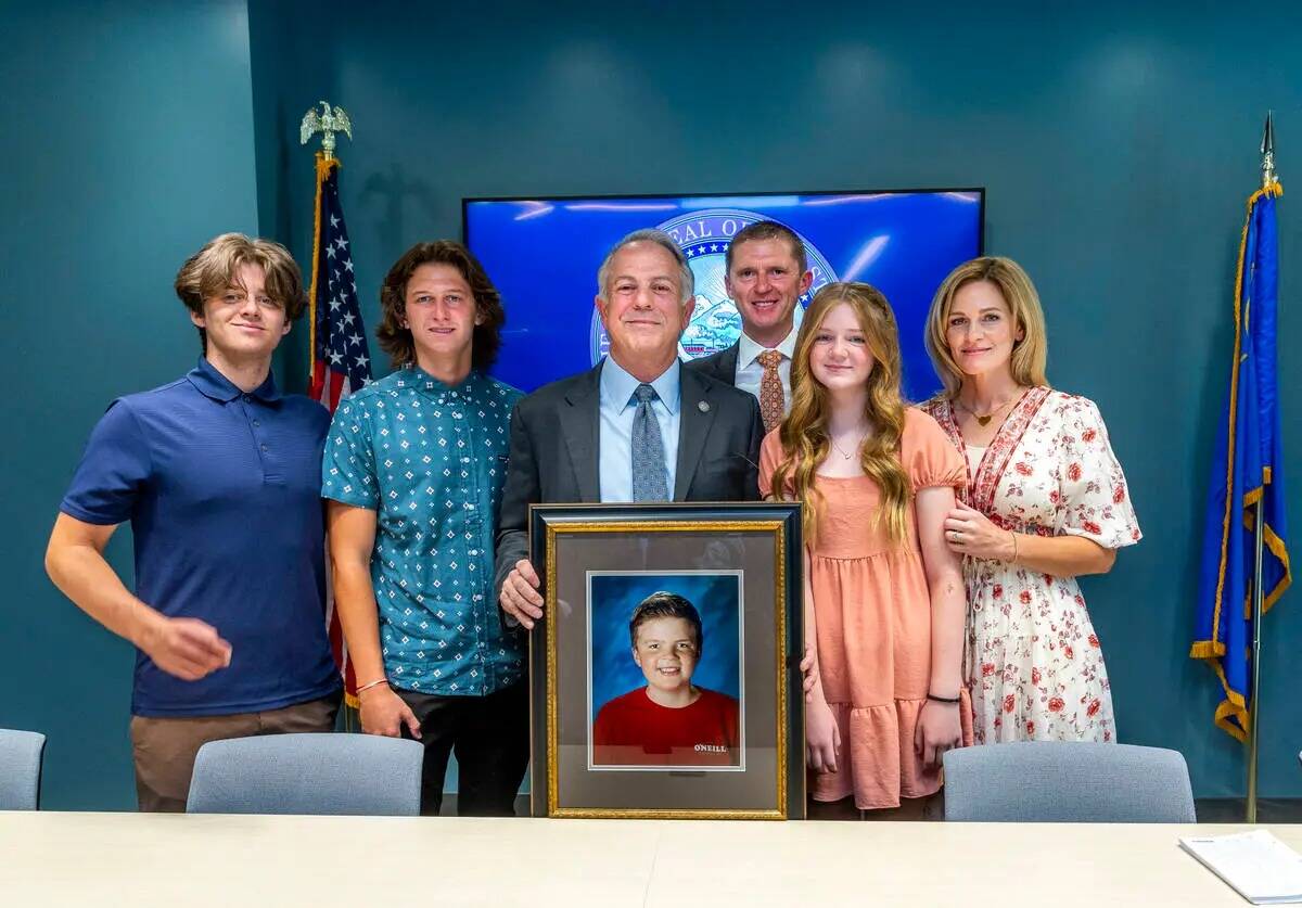 El gobernador de Nevada, Joe Lombardo, sostiene una foto de Rex Patchett junto a los miembros d ...