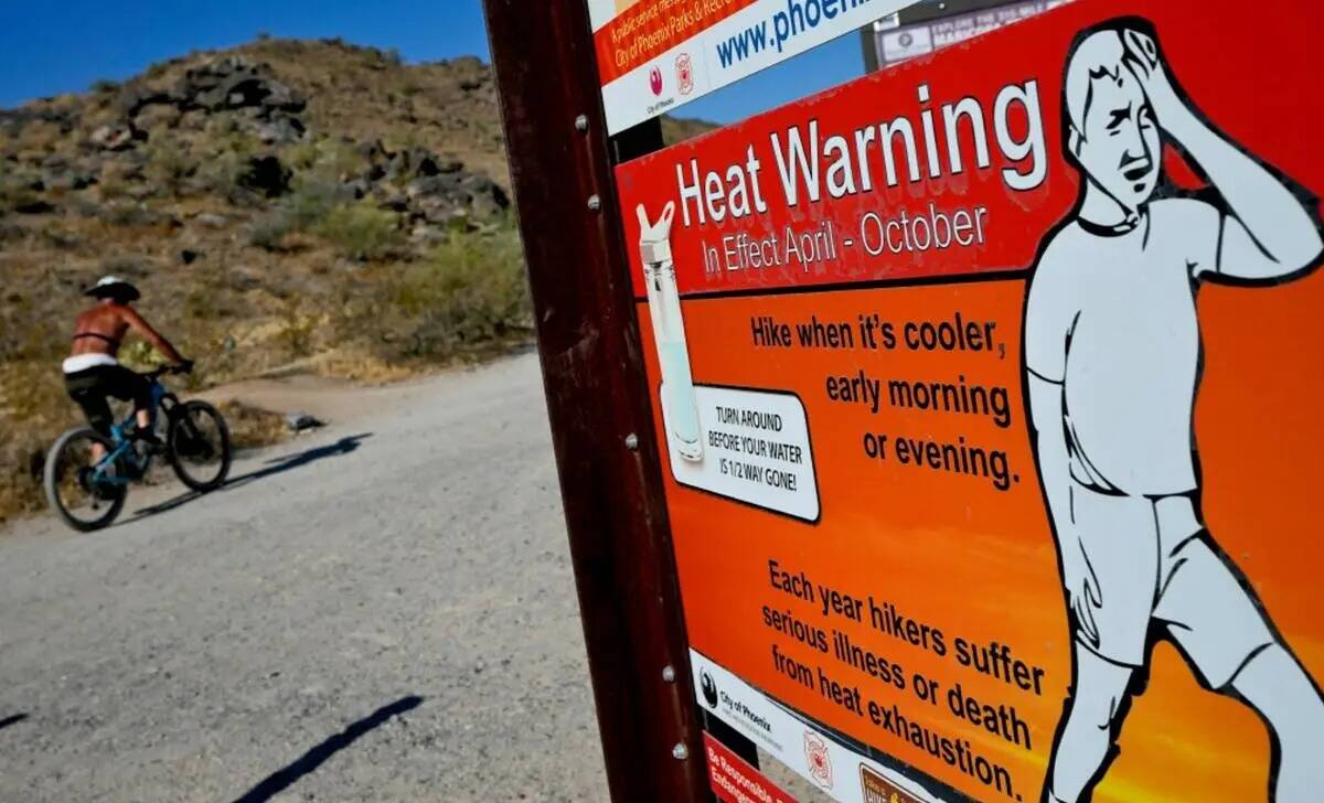 Un ciclista termina su paseo temprano para superar las altas temperaturas, lunes, 10 de julio d ...