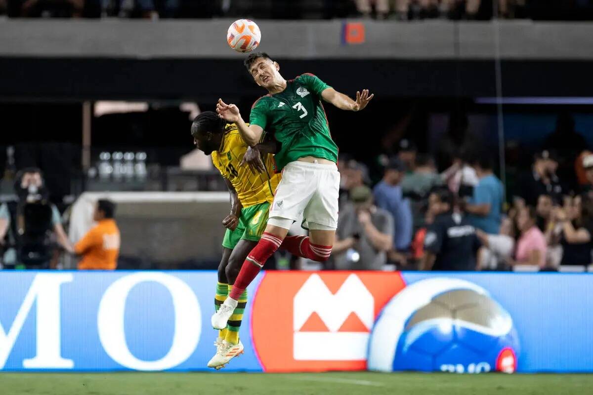 El defensa mexicano César Montes (3) remata de cabeza ante el delantero jamaicano Michail Anto ...