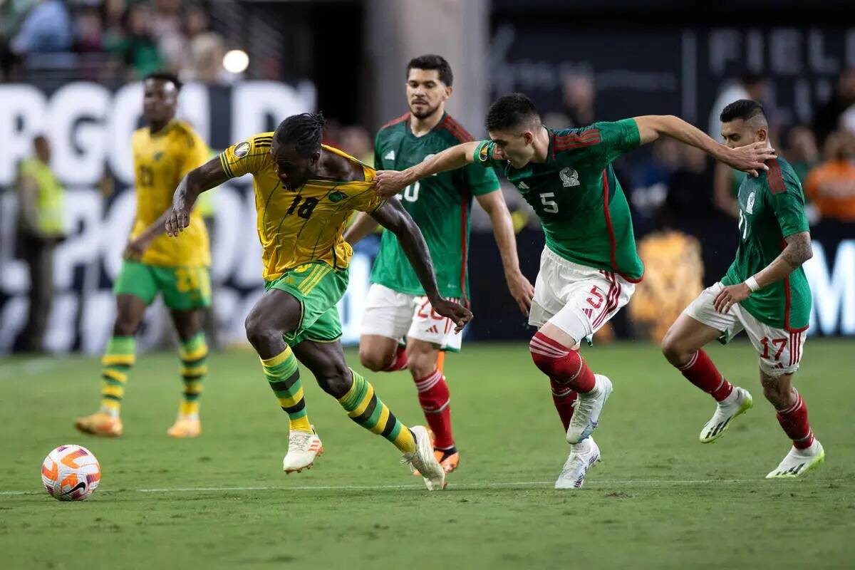 El defensa de México Johan Vásquez (5) toma la camiseta del delantero de Jamaica Michail Anto ...