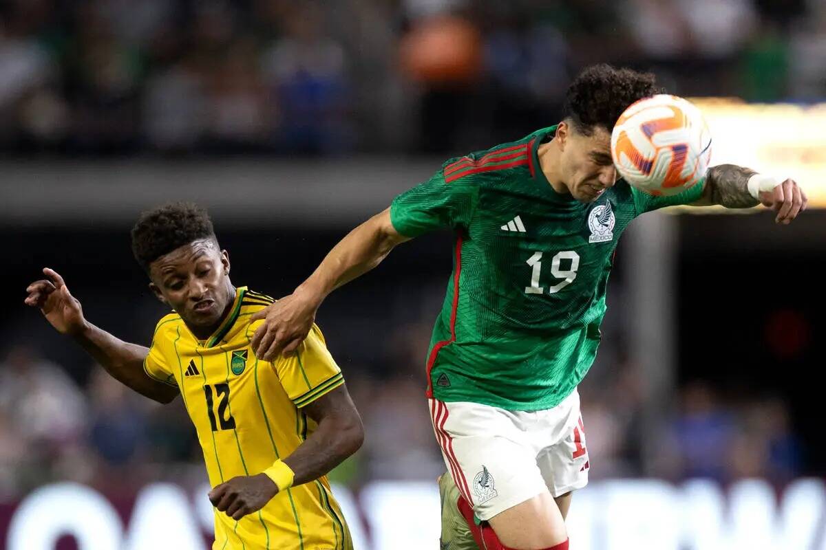 El defensa de México Jorge Sánchez (19) cabecea el balón contra el delantero de Jamaica Dema ...