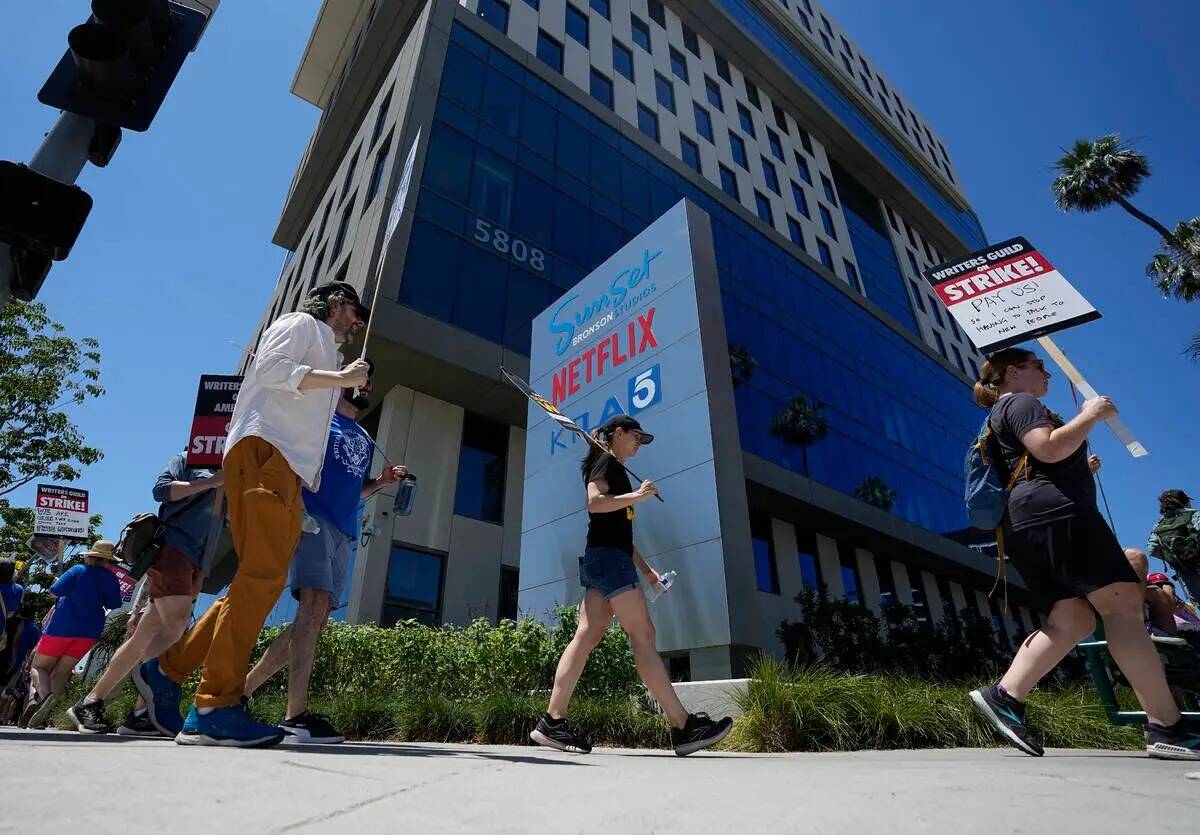 Mnifestantes llevan carteles fuera de Netflix durante una manifestación del Writers Guild el j ...