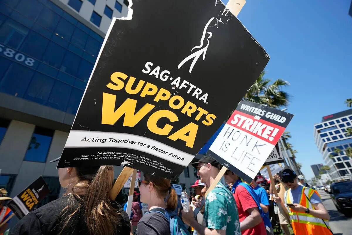 Mnifestantes llevan carteles fuera de Netflix durante una manifestación del Writers Guild el j ...