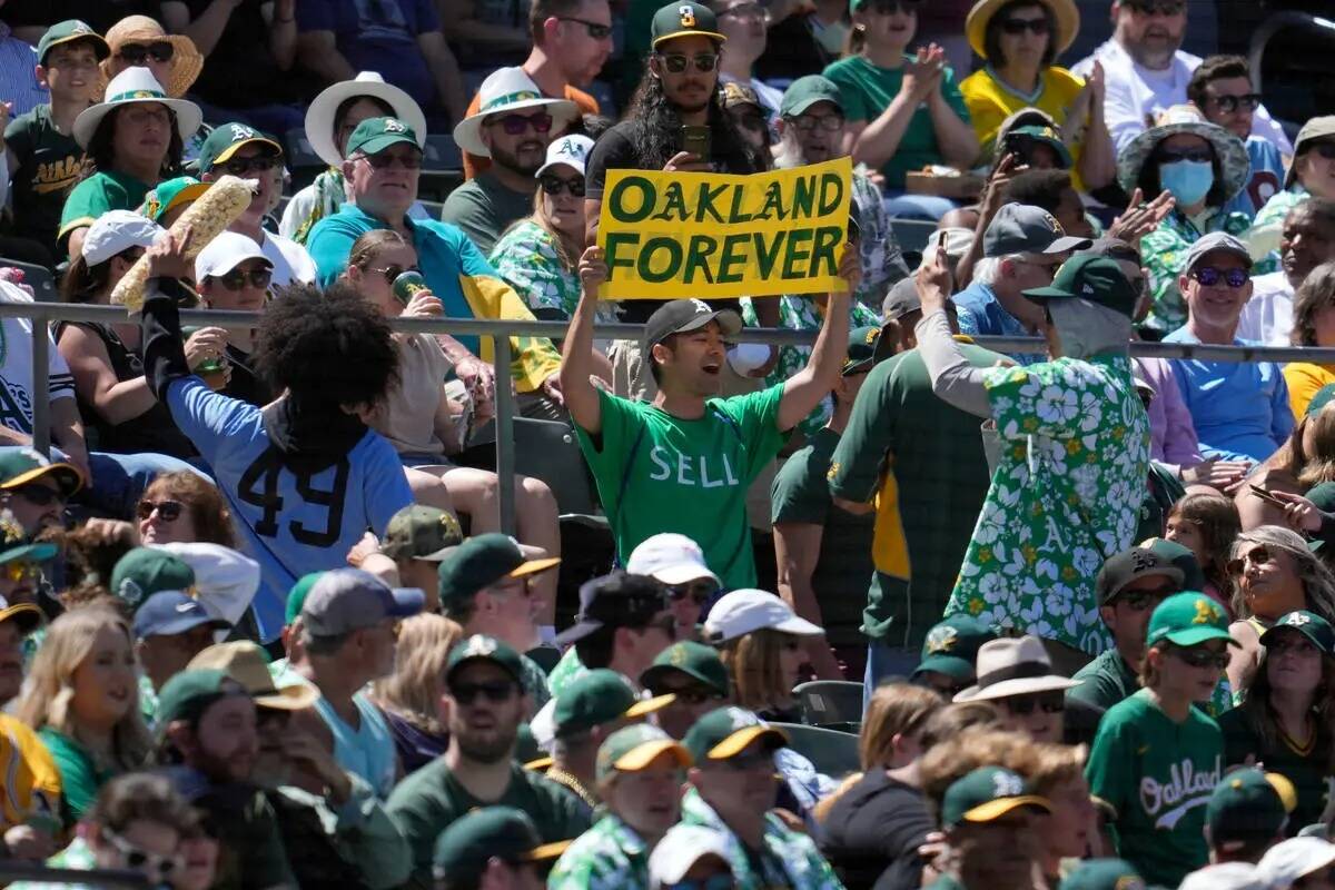Un fan de los Oakland Athletics sostiene un cartel en protesta por el traslado previsto del equ ...