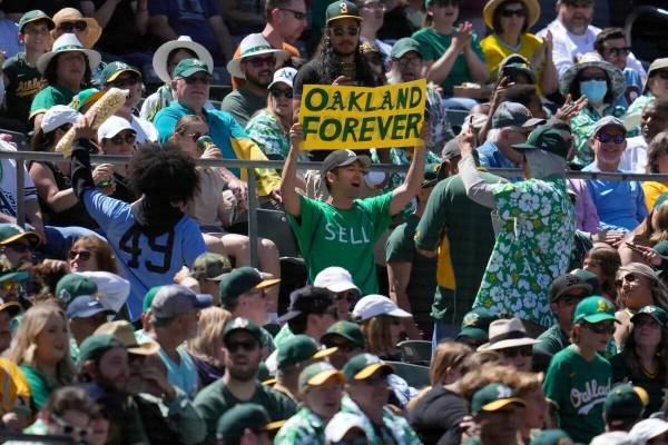 Un fan de los Oakland Athletics sostiene un cartel en protesta por el traslado previsto del equ ...