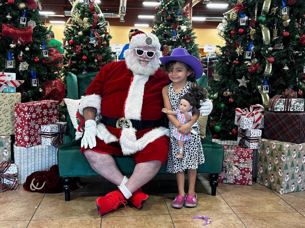 Santa Claus llegó en medio de la nieve que caía a la tienda, donde la alcaldesa de North Las ...