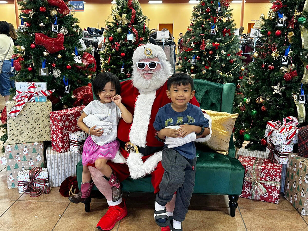 Santa Claus llegó en medio de la nieve que caía a la tienda, donde la alcaldesa de North Las ...