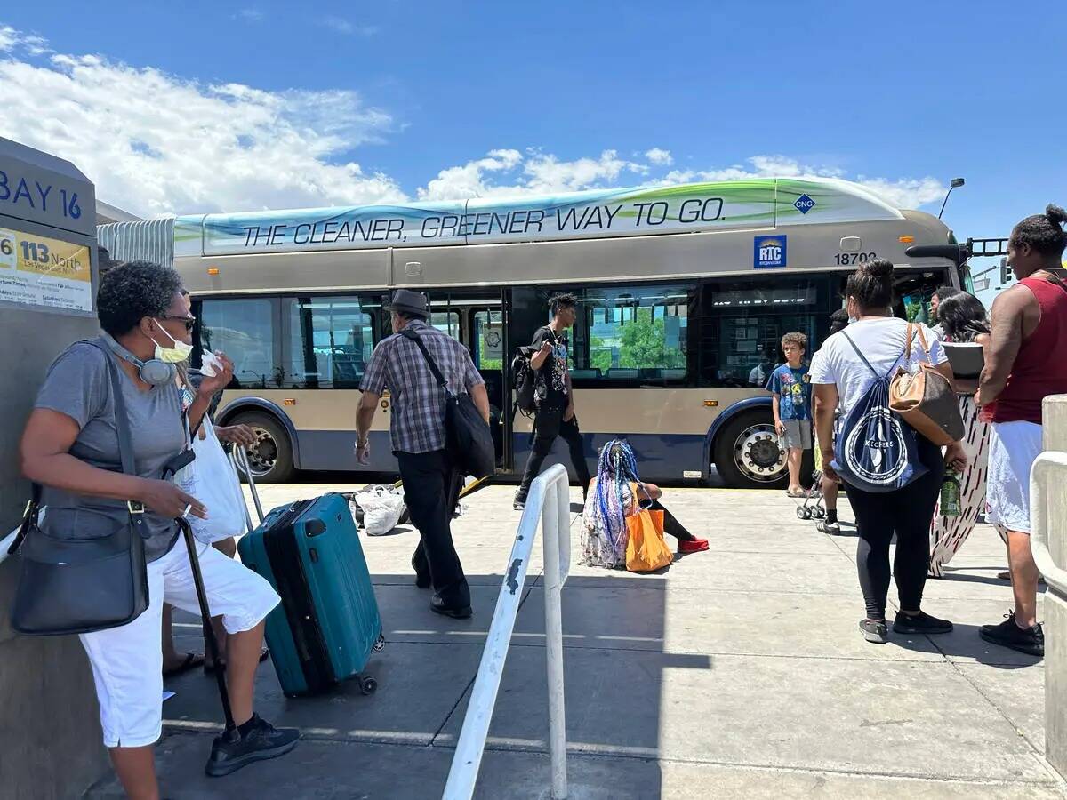 Los pasajeros de autobús se preparan para subir a un autobús de la Comisión Regional de Tran ...