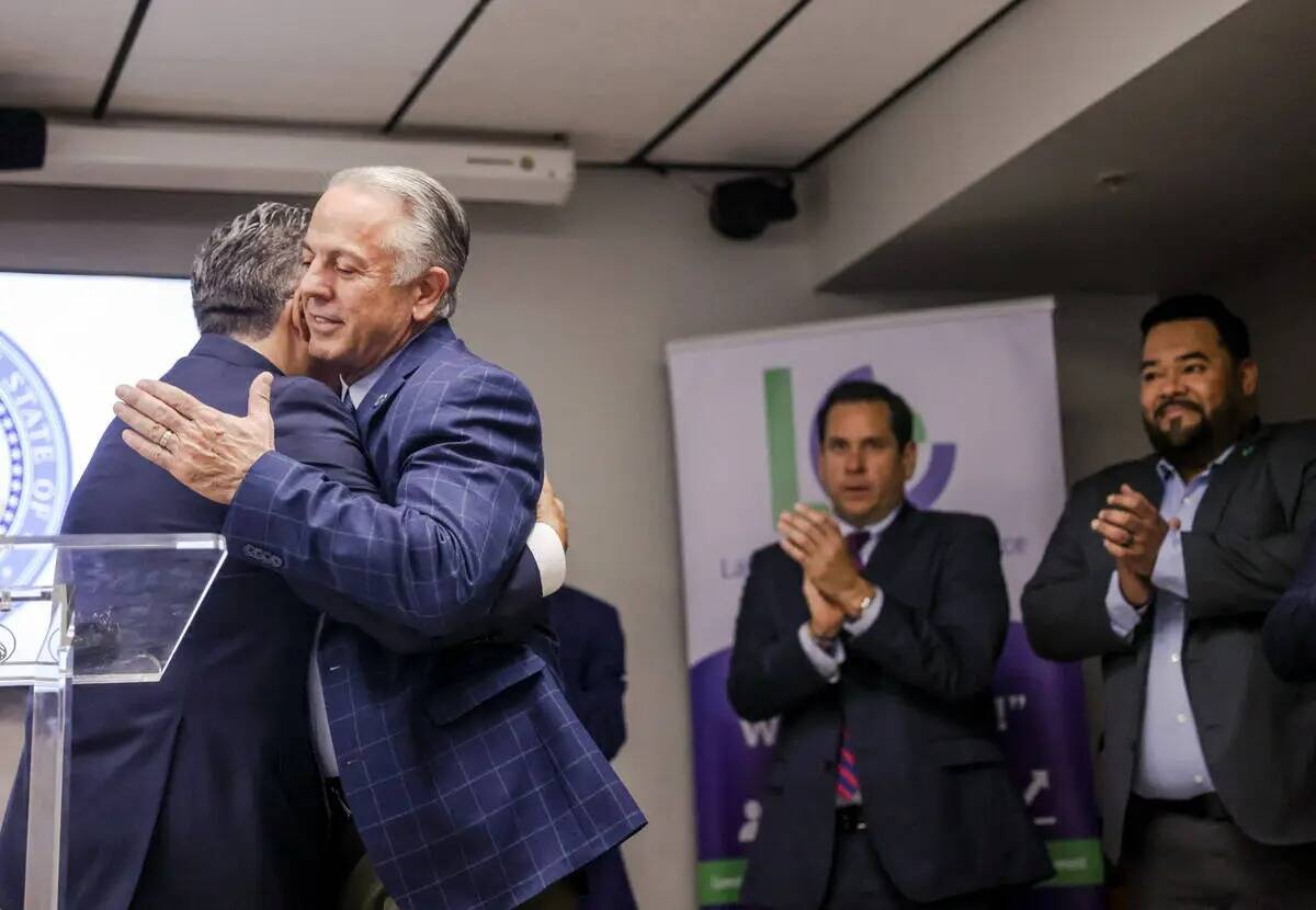 Peter Guzmán, presidente de la Cámara Latina de Comercio, de izquierda, sonríe mientras el g ...