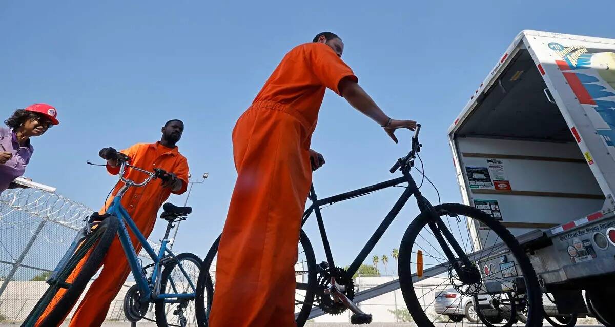 Los reclusos Omar Kemp, en el centro, y Jacquar Sprinkle, a la derecha, descargan bicicletas de ...