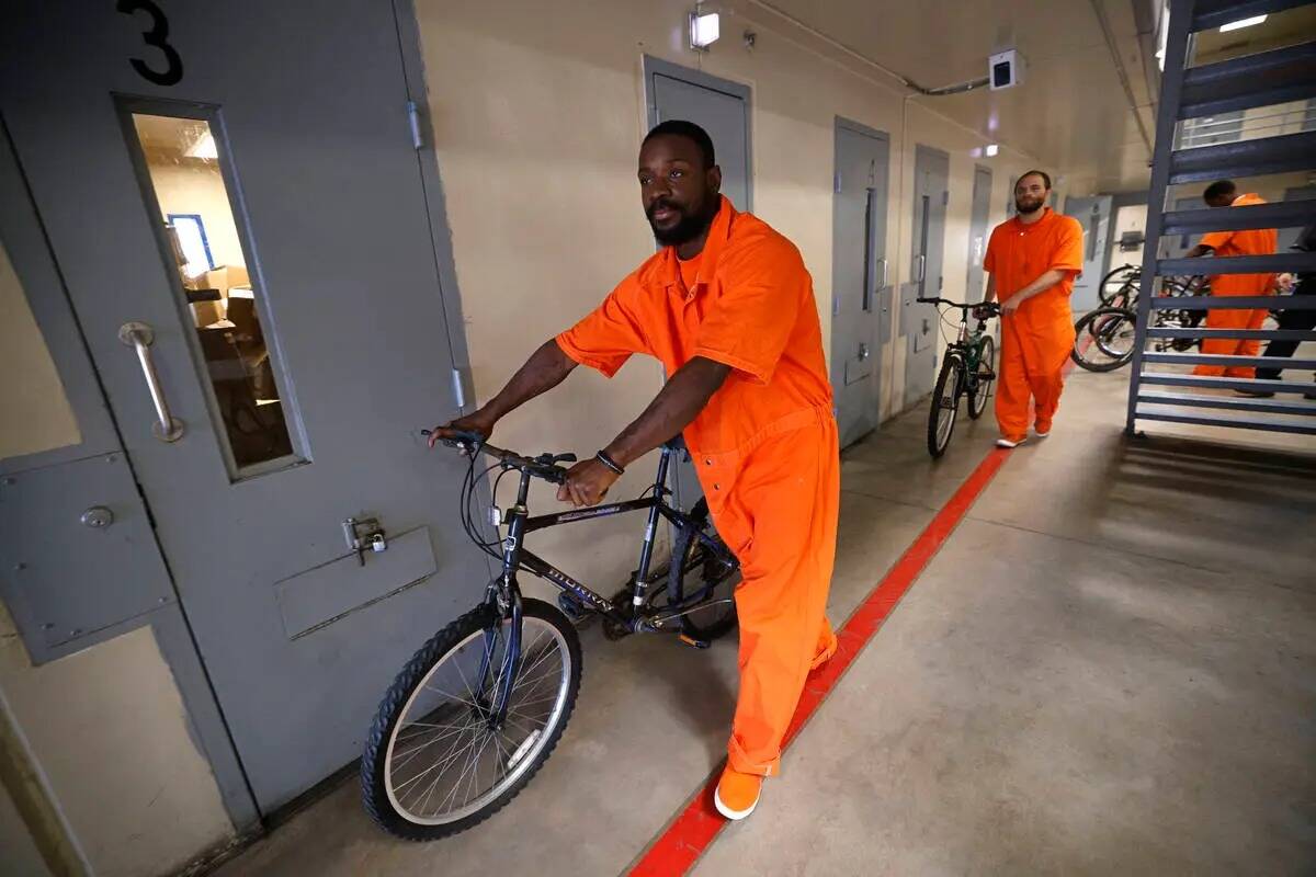 Los reclusos Omar Kemp, a la izquierda, y Jacquar Sprinkle cargan las bicicletas en un camión ...