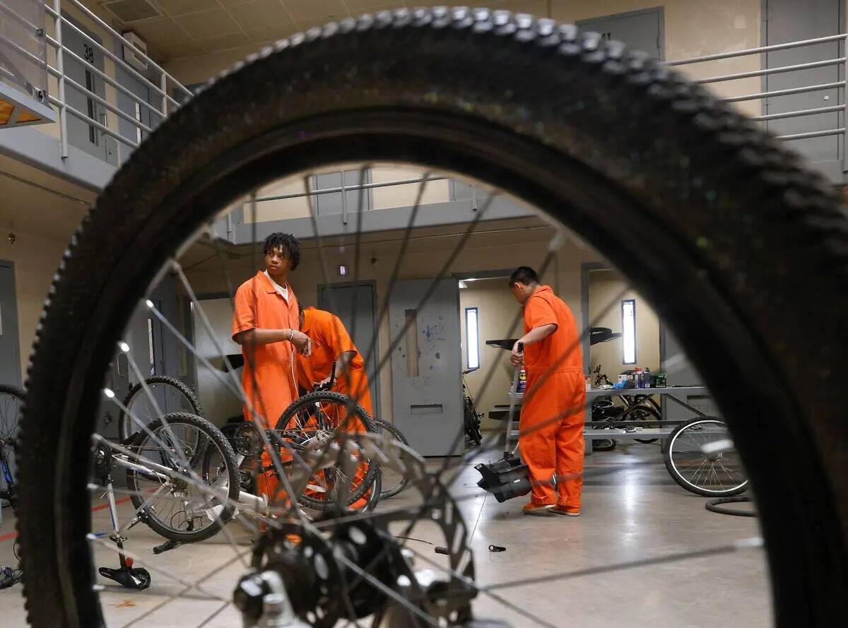 El recluso Erick Wilson, a la izquierda, repara una bicicleta con otros reclusos en el Centro C ...