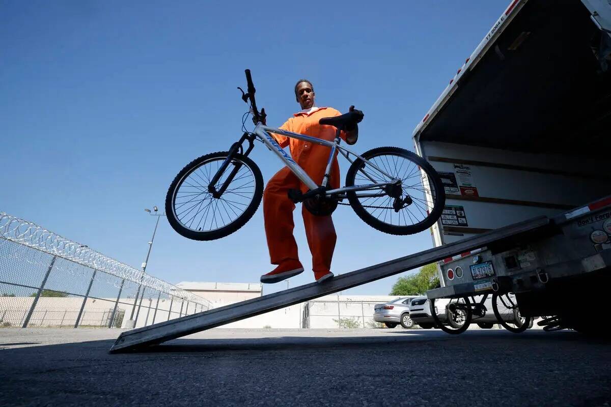 El recluso Ryan Brandon descarga una bicicleta de un camión en el Centro Correccional Comunita ...